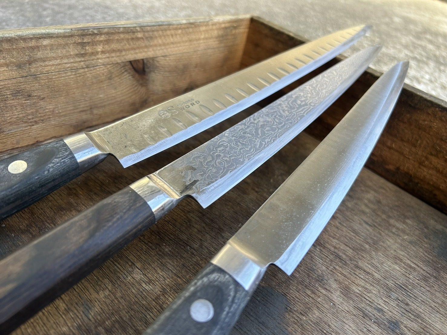 木箱に並んだ包丁の、光を返す刃面