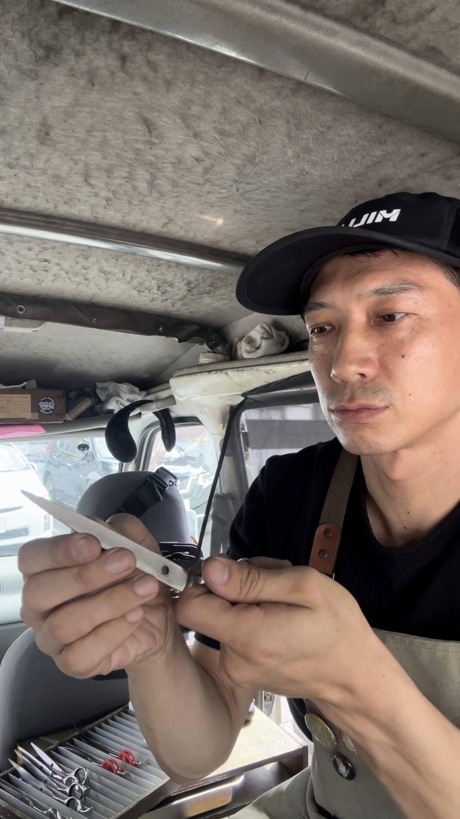 ハサミの刃を手で確かめながら砥ぐ金森さん