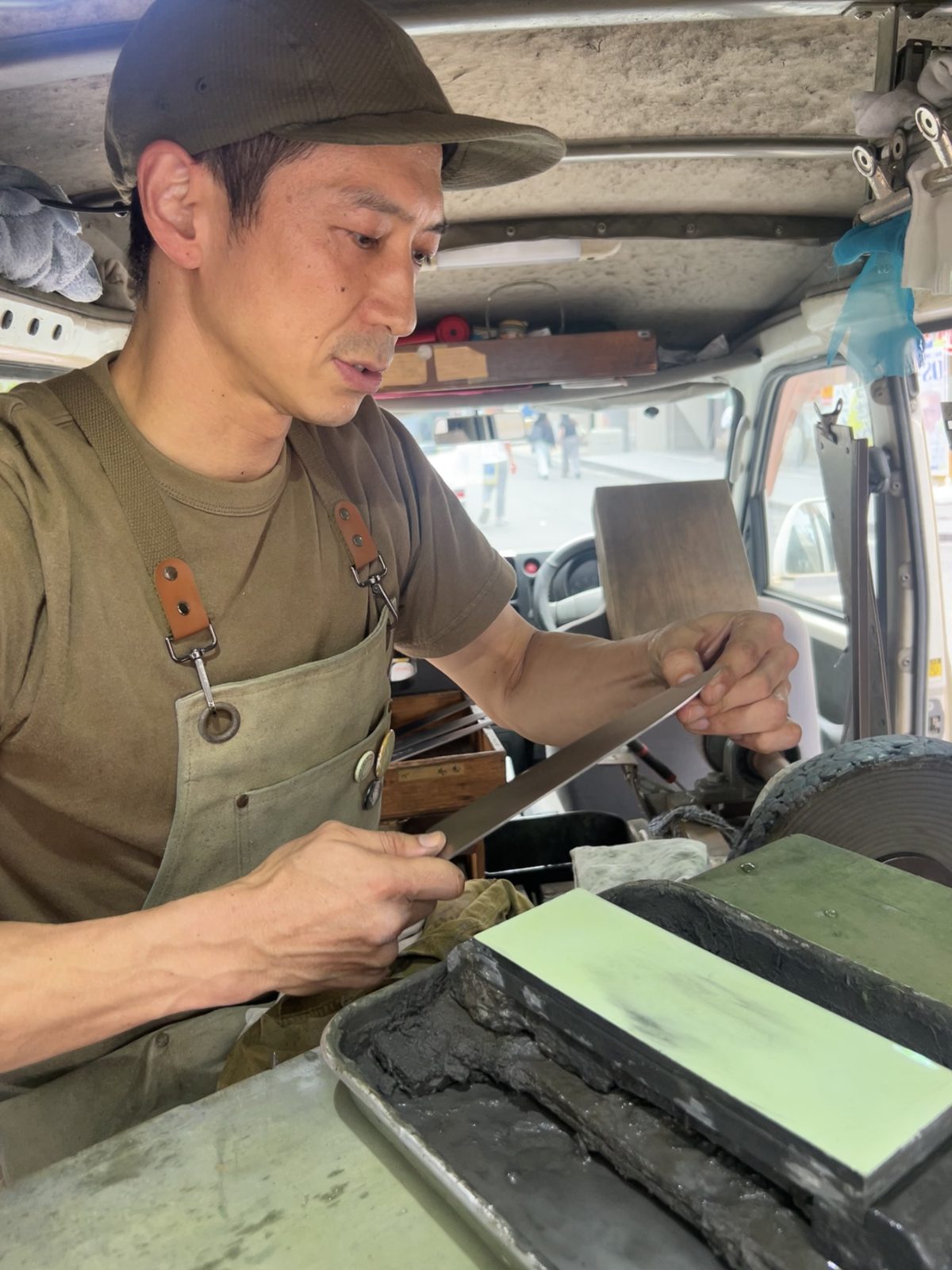 専用車の中で砥石に向かう砥ぎ師 金森俊樹